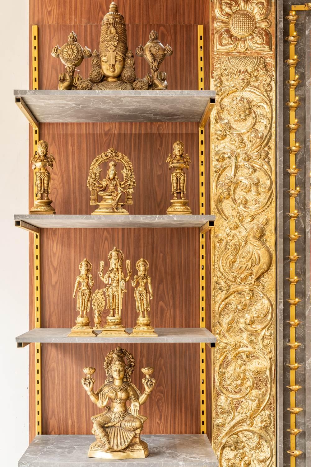 Brass idol display shelving in a traditional pooja and home store by Arch Decode